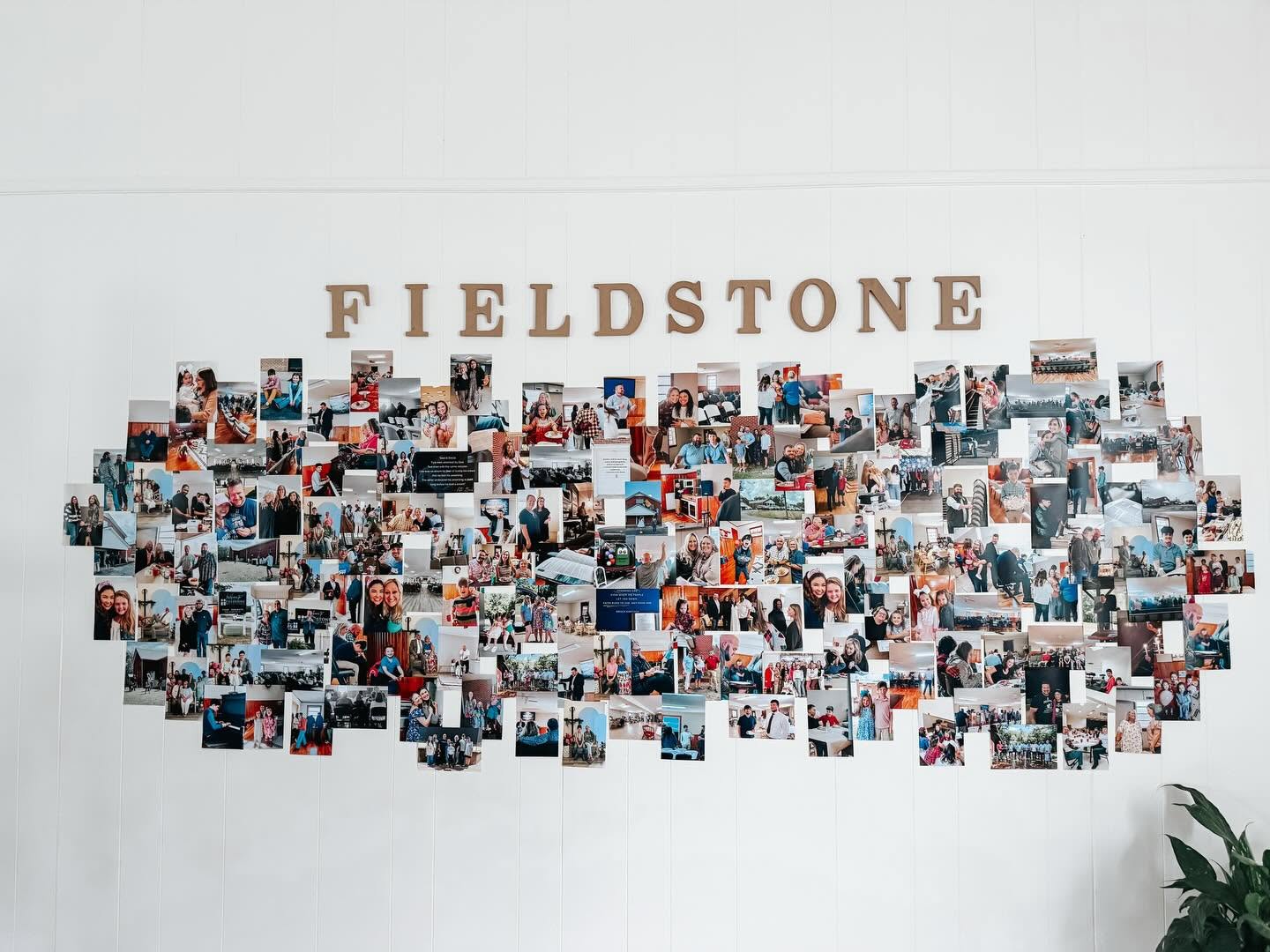 A wall at Fieldstone covered with photographs of church life